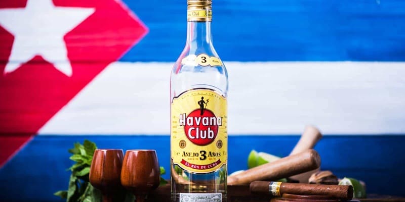 botella havana club de ron cubano con bandera de Cuba de fondo